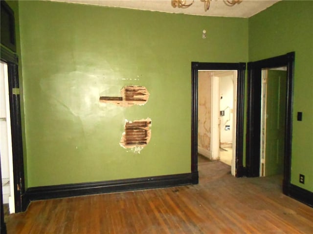 198 W Pearl St, City Of But Nw, PA 16001 - empty room featuring a chandelier, baseboards, and wood finished floors
