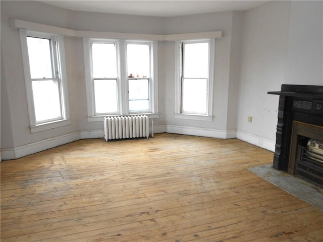 198 W Pearl St, City Of But Nw, PA 16001 - unfurnished living room with radiator heating unit, a wealth of natural light, light wood-style floors, and baseboards
