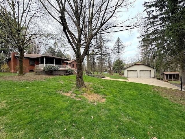 view of yard with a porch, a detached garage, and an outdoor structure