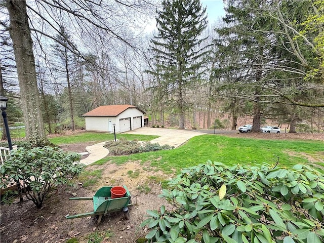 view of yard with a detached garage and an outdoor structure
