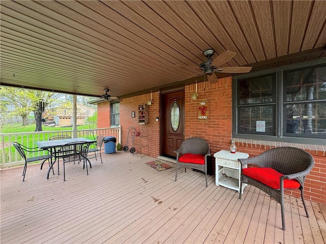 wooden deck with a ceiling fan and outdoor dining area