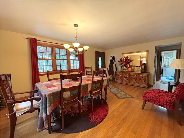 dining room featuring light wood finished floors and a notable chandelier