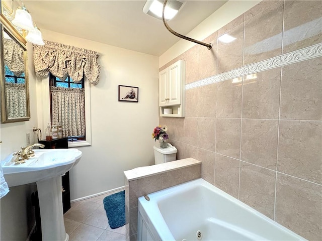 bathroom featuring baseboards, a whirlpool tub, and tile patterned flooring