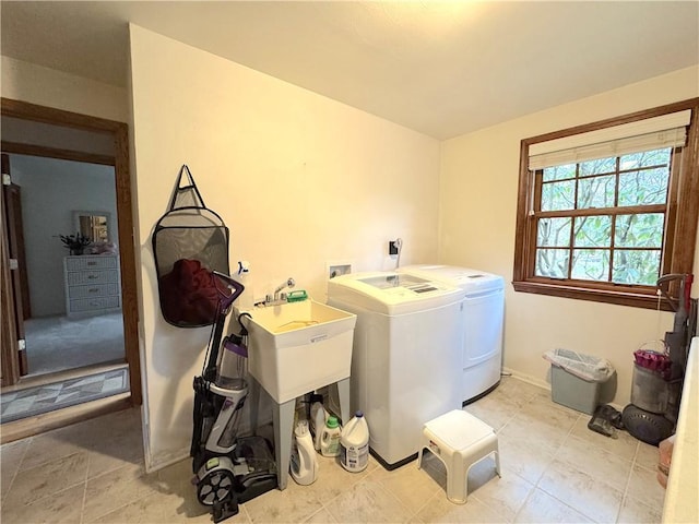 laundry room featuring washer and dryer, laundry area, light tile patterned floors, and a sink