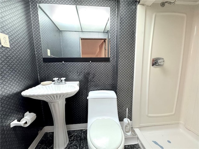 bathroom with a shower stall and toilet