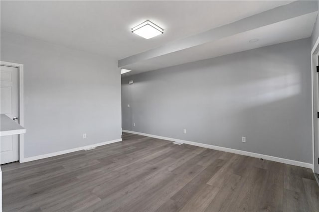 unfurnished room featuring baseboards and wood finished floors