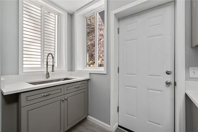 doorway featuring a sink and baseboards