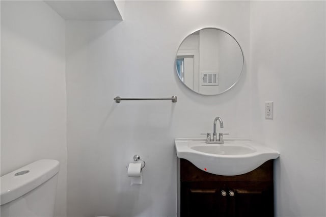 bathroom featuring visible vents, toilet, and vanity