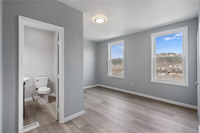 unfurnished bedroom featuring light wood-style floors and baseboards