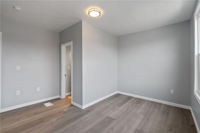 unfurnished room featuring baseboards and wood finished floors