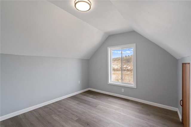bonus room featuring wood finished floors, baseboards, and vaulted ceiling