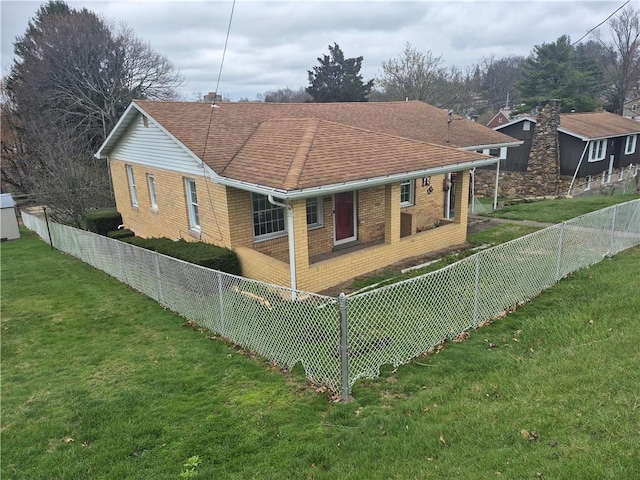 back of house with brick siding, a yard, roof with shingles, and fence private yard