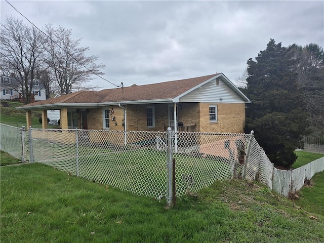 back of house with brick siding, a yard, and fence private yard