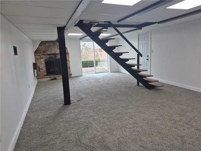 below grade area featuring stairs, carpet, and an outdoor stone fireplace