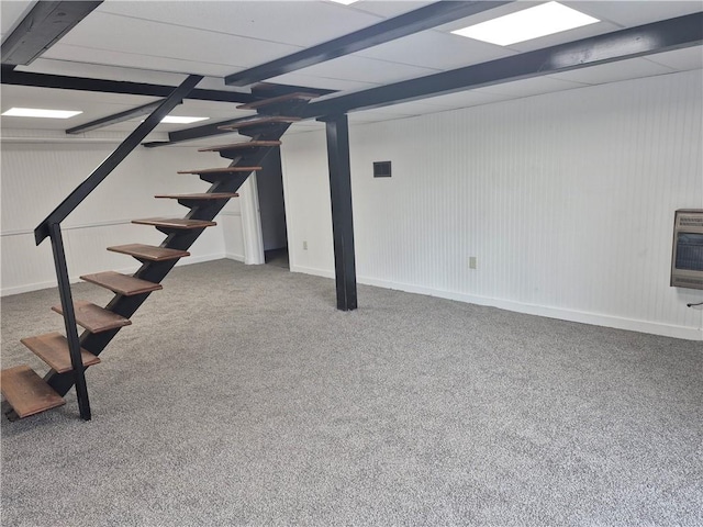 finished below grade area with carpet floors, heating unit, visible vents, and stairway