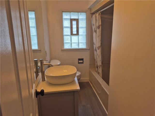 full bathroom featuring vanity, baseboards, toilet, shower / bathtub combination with curtain, and wood finished floors