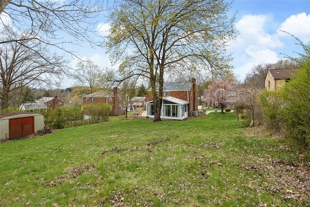 view of yard featuring a storage shed and an outbuilding