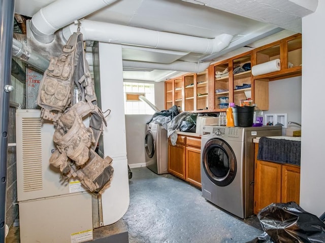 clothes washing area with cabinet space, independent washer and dryer, and baseboards