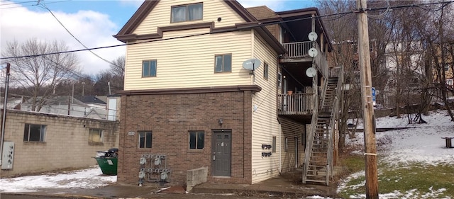 420 Broadway Ave, Mckees Rocks, PA 15136 - snow covered back of property with stairs and brick siding