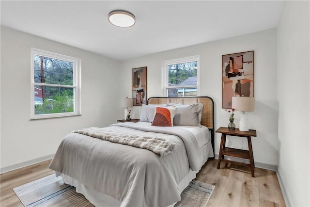 bedroom featuring baseboards and light wood finished floors