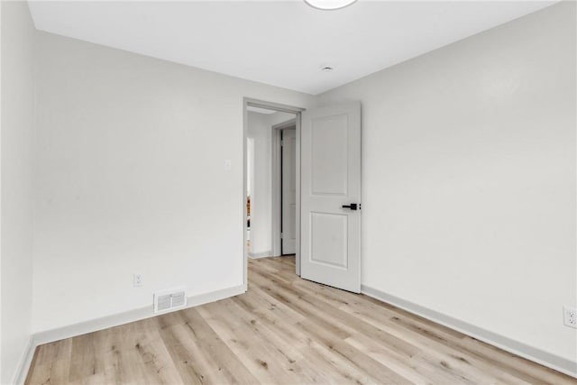 spare room with visible vents, baseboards, and wood finished floors