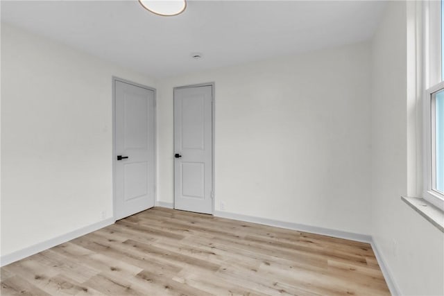 empty room with baseboards and wood finished floors
