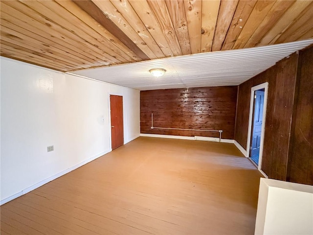 finished basement with wood walls, baseboards, wooden ceiling, and wood finished floors