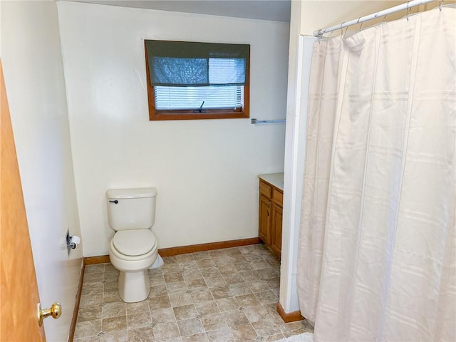 full bath with toilet, a shower with shower curtain, vanity, and baseboards