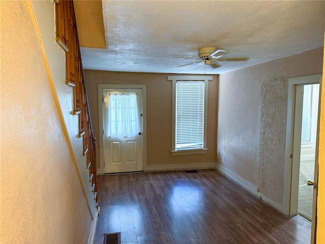 foyer entrance featuring visible vents, ceiling fan, baseboards, and wood finished floors
