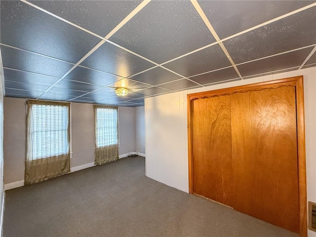 interior space featuring visible vents, a drop ceiling, and carpet flooring