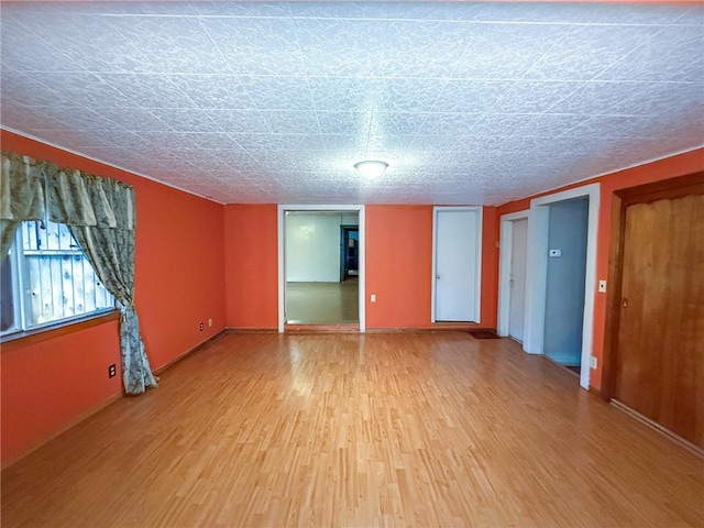 spare room featuring light wood-style floors and baseboards
