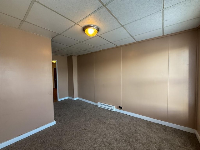 carpeted empty room with baseboards, a drop ceiling, and visible vents