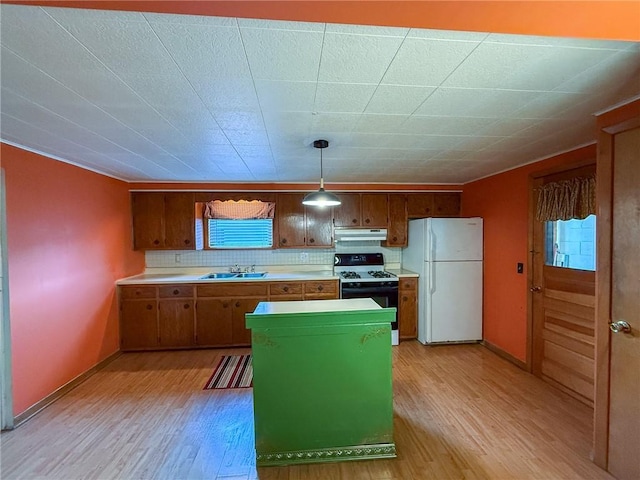 kitchen featuring freestanding refrigerator, under cabinet range hood, light wood-style floors, and gas range oven