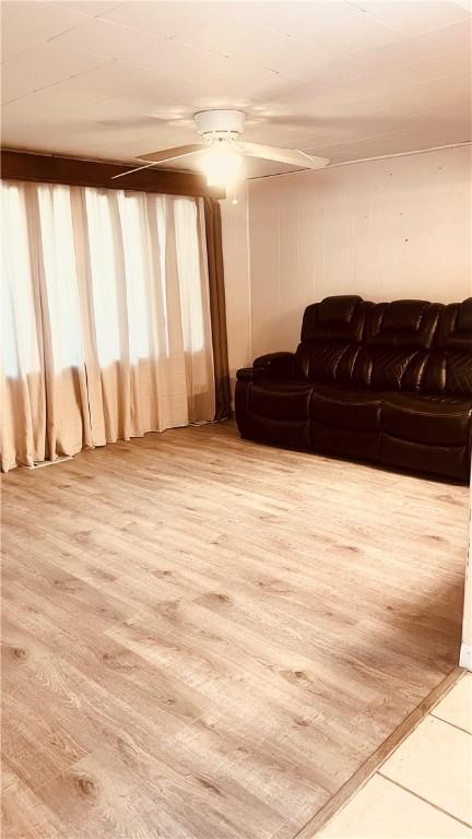 living area with wood finished floors and ceiling fan