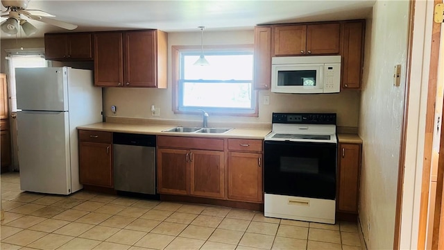 kitchen with light tile patterned floors, a sink, light countertops, ceiling fan, and white appliances