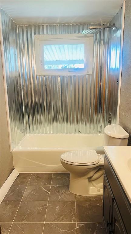 bathroom featuring washtub / shower combination, toilet, and vanity