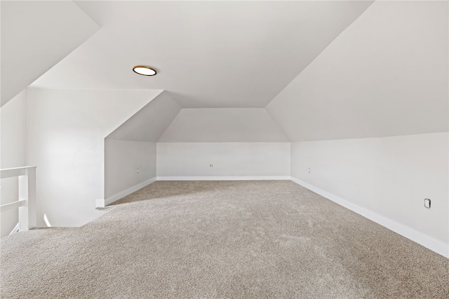 additional living space with baseboards, vaulted ceiling, and carpet floors