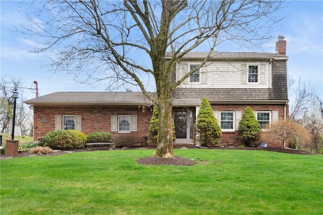 traditional home with a front yard, a shingled roof, brick siding, and a chimney