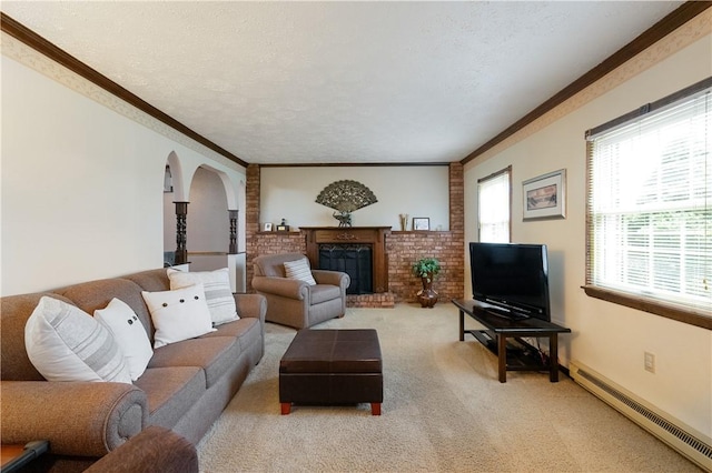 living area featuring arched walkways, a baseboard heating unit, ornamental molding, a fireplace, and light colored carpet