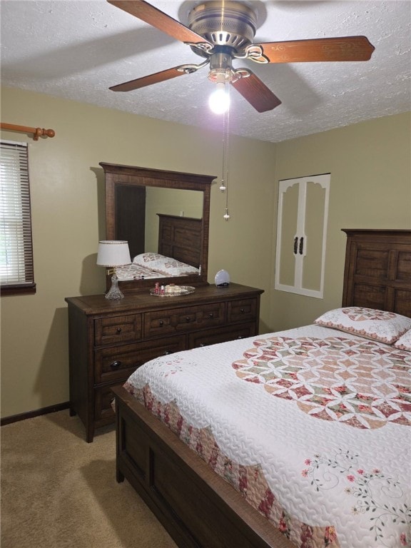 bedroom with a textured ceiling, light colored carpet, and ceiling fan
