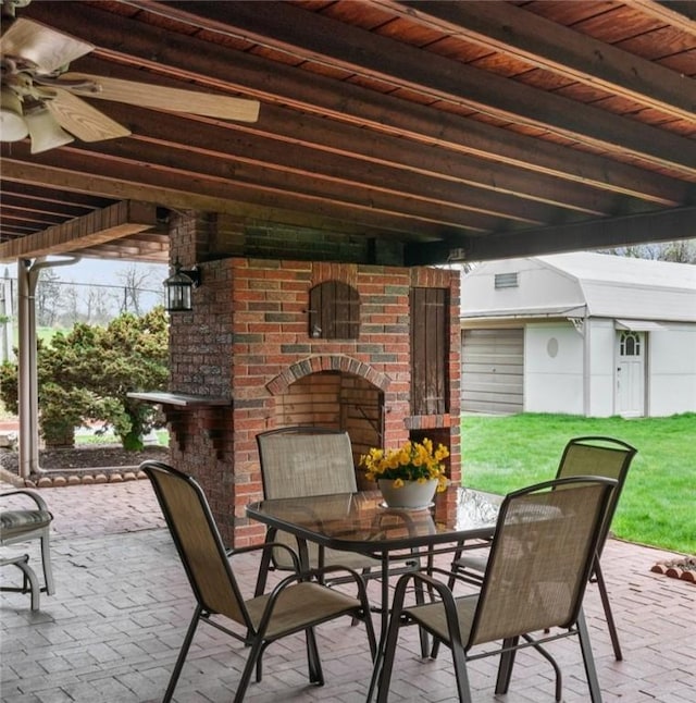 view of patio with outdoor dining area and an outdoor brick fireplace