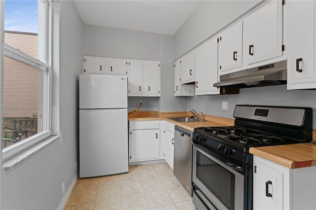 1968 Straubs Ln, Troy Hill, PA 15212 - kitchen with white cabinets, under cabinet range hood, light countertops, a sink, and stainless steel appliances