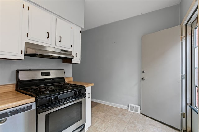 1968 Straubs Ln, Troy Hill, PA 15212 - kitchen with light countertops, white cabinets, under cabinet range hood, visible vents, and appliances with stainless steel finishes