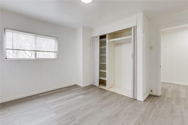 unfurnished bedroom with wood finished floors, a closet, and baseboards