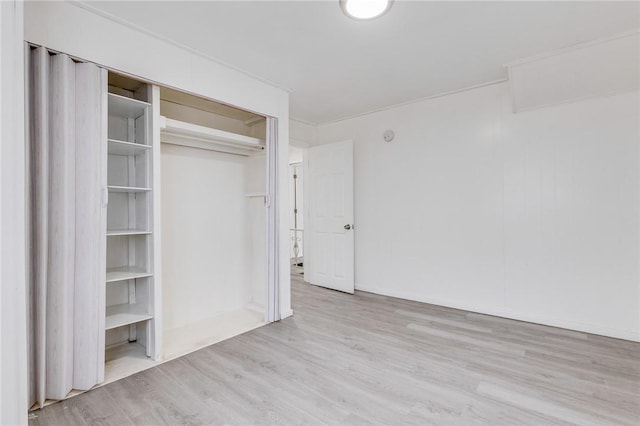 unfurnished bedroom with wood finished floors and a closet