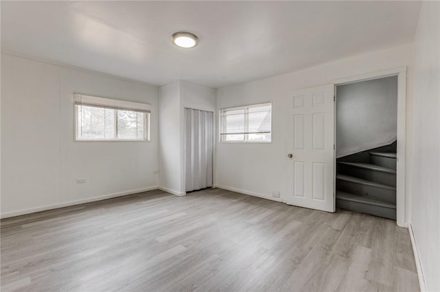 unfurnished bedroom featuring light wood-style flooring and baseboards