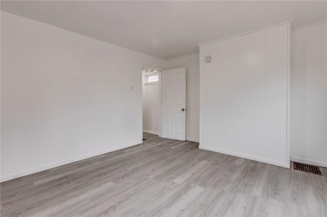 spare room with visible vents, baseboards, and wood finished floors