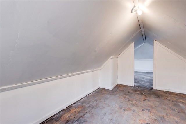 bonus room featuring concrete flooring and vaulted ceiling