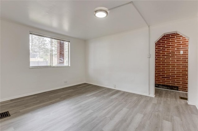 unfurnished room with visible vents, baseboards, crown molding, and wood finished floors