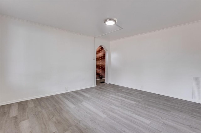 unfurnished room featuring crown molding, wood finished floors, baseboards, and visible vents